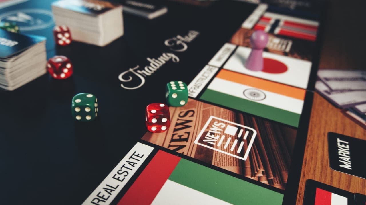 Trading Floor logo with game components, dice, and NEWS cards